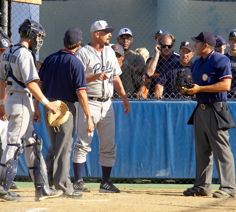 Palisades Coach Tom Seyler protests to home plate umpire Chris Chegwin after Dolphins' pitcher Andy Megee was ejected for hitting a batter in the sixth inning of last week's City semifinal game.